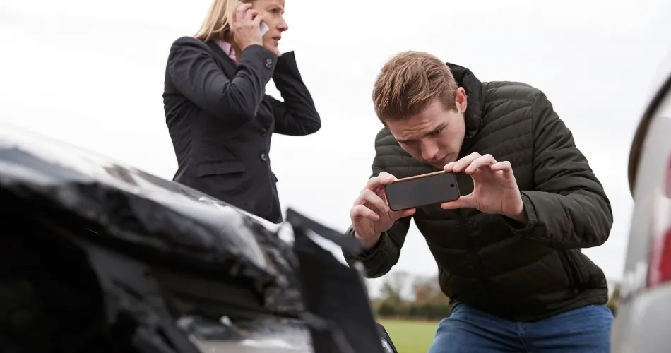 man taking photos of a car accident